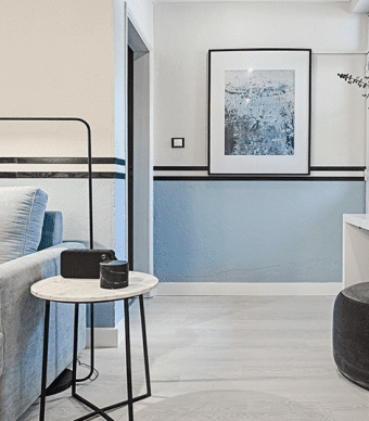 Sala com paredes pintadas na parte de baixo de azul e em cima de branco com um friso de madeira preto a separar